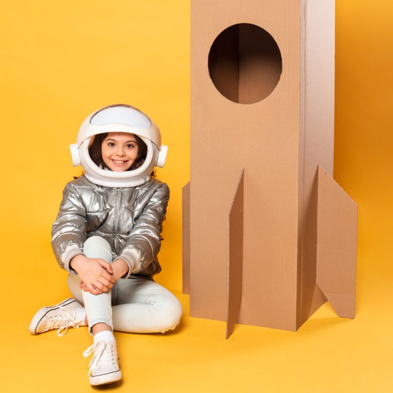 girl-sitting-beside-space-ship-cartoon-toy